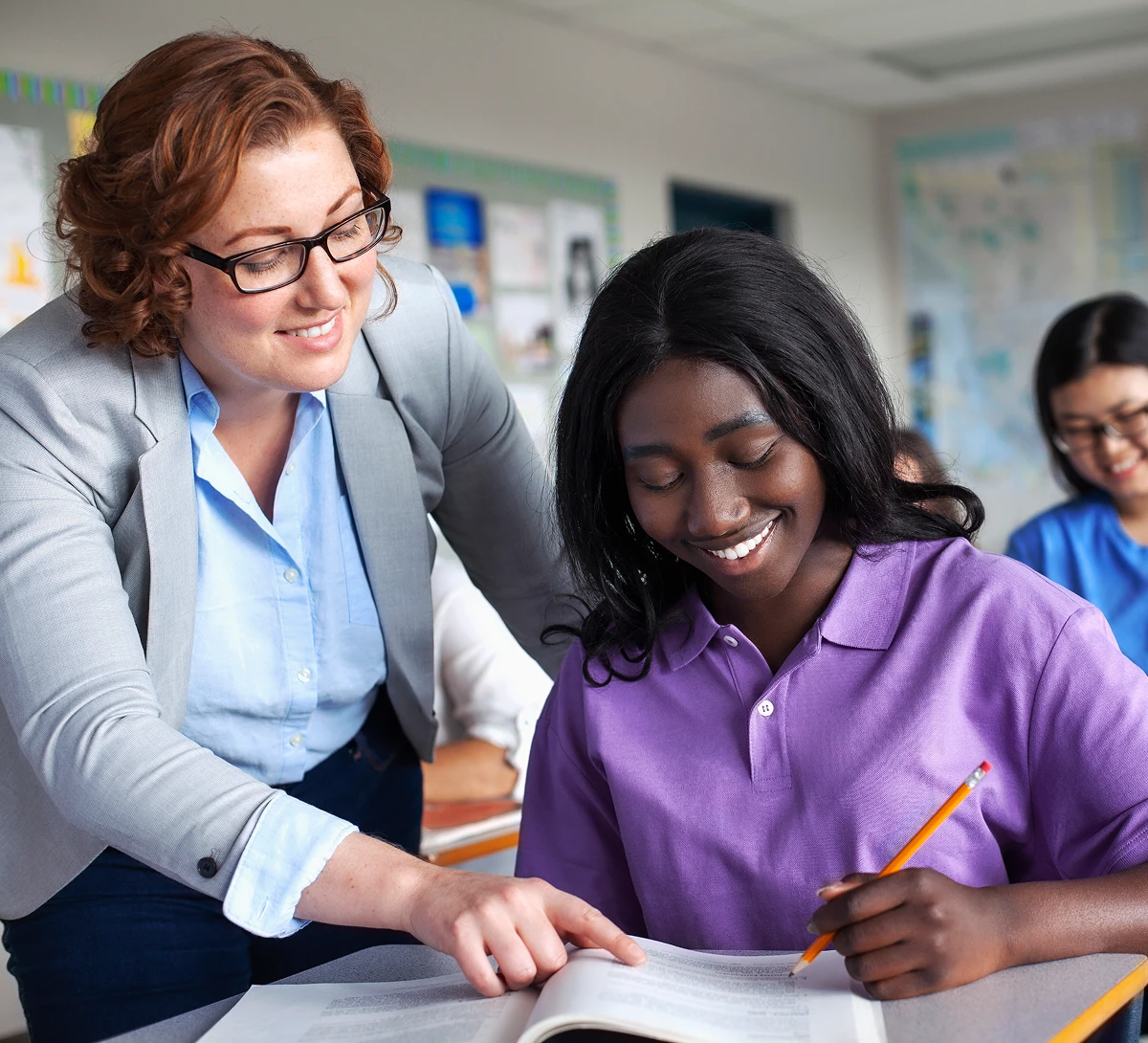 Teacher helping student in classroom
