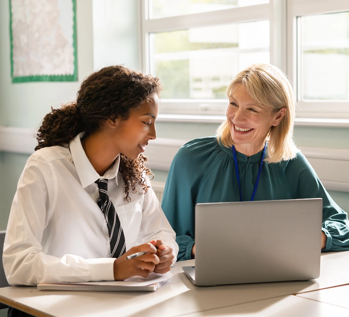 Teacher helping student with laptop